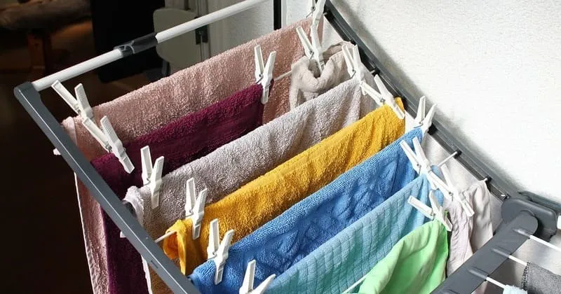 室内の物干しラックに並ぶ色違いのタオル