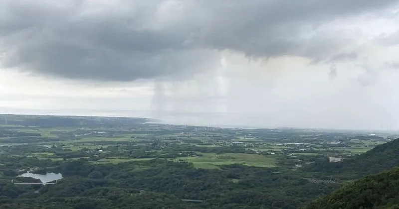 厚い梅雨雲と遠景の街、石垣島の平野部