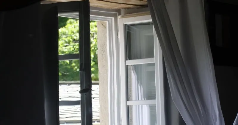 開いた窓と揺れるカーテン、外気が入る室内