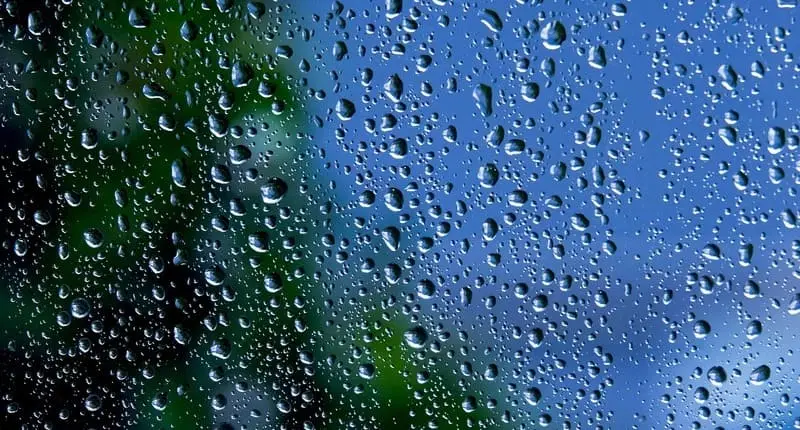 雨上がりの窓ガラス、雨粒と青空の反射が残る