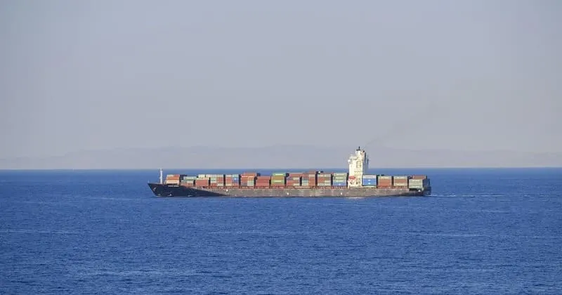 遠くの海を進むコンテナ船と静かな水平線