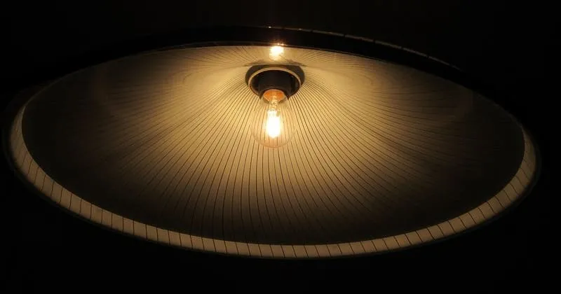 点灯した電球とシェードを真下から写す