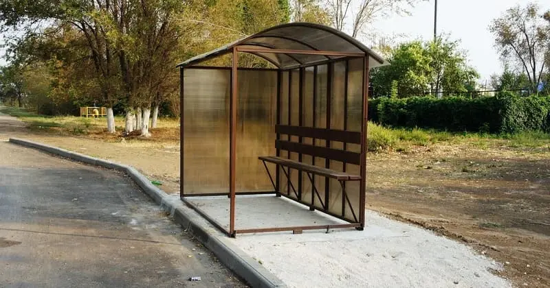 屋根付きのバス停とベンチ。雨をしのげる待合スペースのイメージ画像。