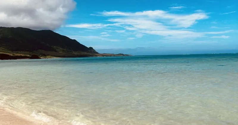 浅い海と砂浜、雲が流れる午後の海辺