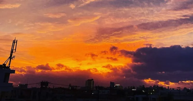 橙色の雲が広がる夕空と低い街並み