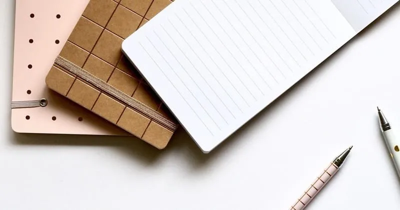 白いデスクに置いたノートと筆記具、静かな夜の準備