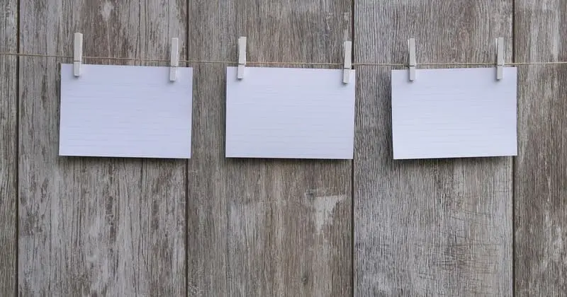 白いメモが三枚並ぶロープと木目の壁面、静かな室内