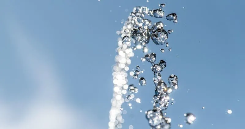 青空に伸びる噴水の水流と飛沫