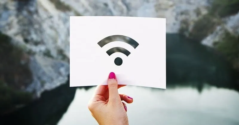 水辺と岩場を背景にしたWi-Fiマークの白いカード