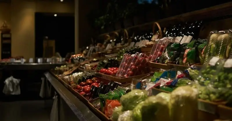 落ち着いた照明のスーパー青果売り場と通路