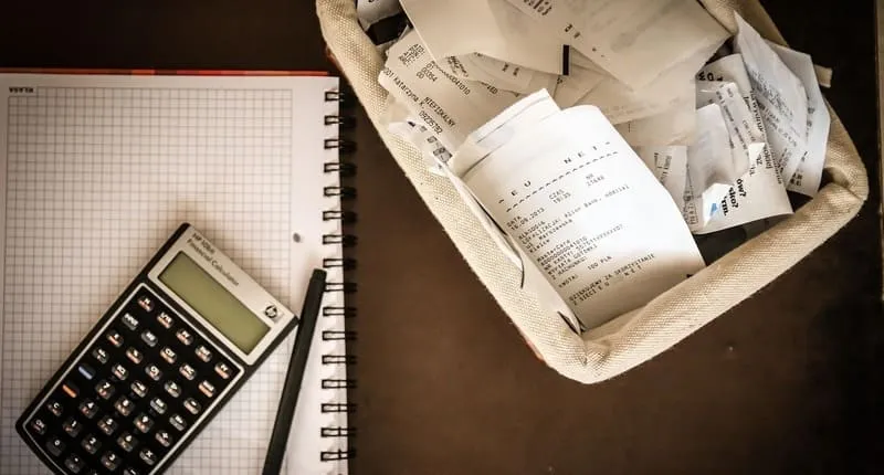 電卓とレシートでひと月の支出を確認する手元