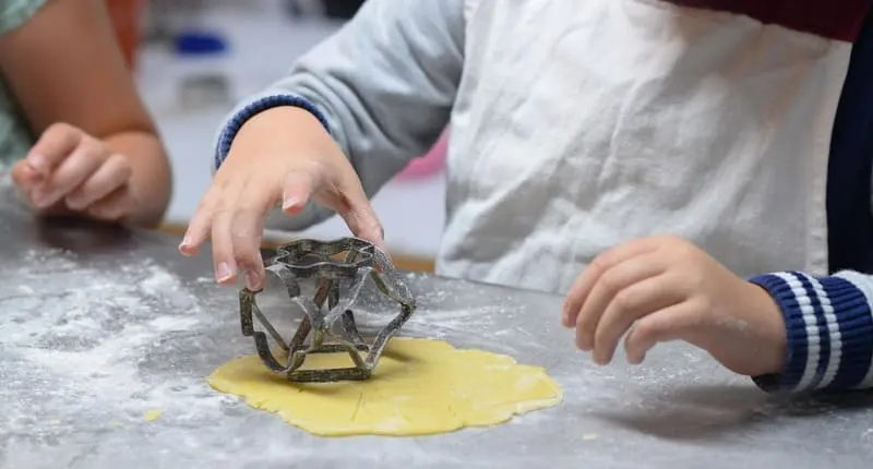 子どもの手が型を押す粉まみれの台