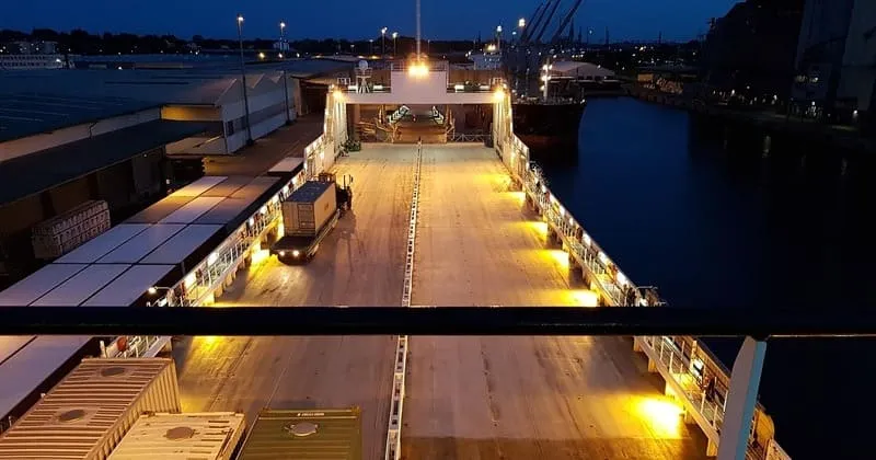 夜の港で貨物を積むフェリー甲板