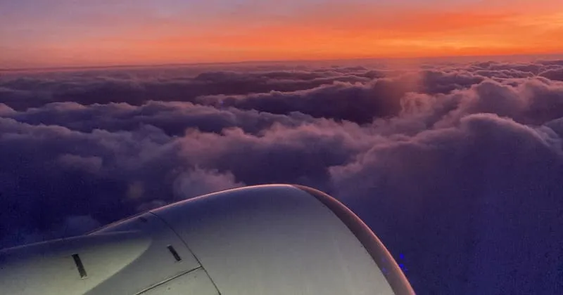 機体の翼越しに広がる雲海と夕景