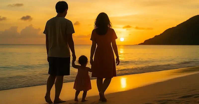 夕日を背に並ぶ親子の後ろ姿と海