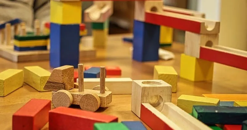 テーブルの上に散らばった木製ブロックとおもちゃ