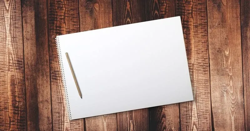 木の机に置いた白いノートと鉛筆