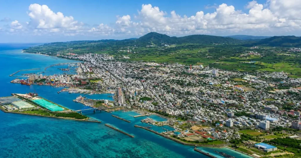 石垣島の海沿いに広がる市街地と港を上空から見た風景