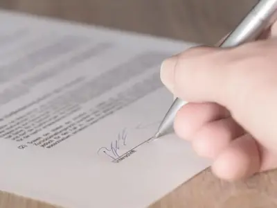 契約書に署名する手元を近接で写す