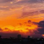 夕焼けの雲と島の街並みのシルエット