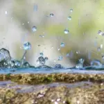 公園の噴水の縁で弾ける水しぶきの近景