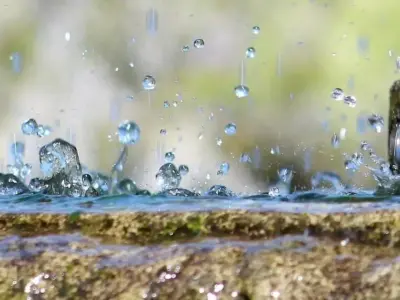 公園の噴水の縁で弾ける水しぶきの近景