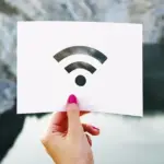 Wi-Fiマークの白いカードを手に持つ人物の写真