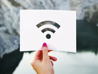 Wi-Fiマークの白いカードを手に持つ人物の写真