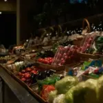 夜のスーパー青果売り場に並ぶ野菜と果物