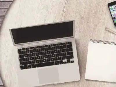 丸テーブルにノートPCとメモ帳とスマホを置いた作業机