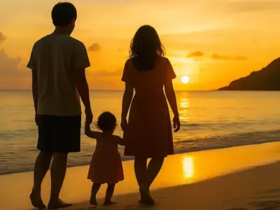 夕焼けの浜辺を歩く家族のシルエット