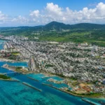 石垣島の海沿いに広がる市街地と港を上空から見た風景