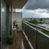 雨に濡れた石垣島のベランダと曇り空の街並み